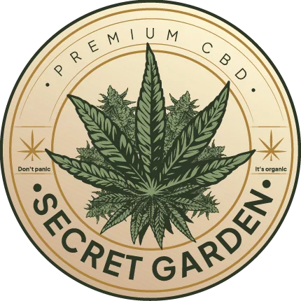 The image shows a circular logo for "Secret Garden." The logo features a detailed, symmetrical design with a large cannabis leaf in the center, surrounded by smaller leaf motifs and decorative elements. The main colors are green for the leaves and a light tan for the background. The text "Secret Garden" is integrated at the bottom of the circle in a stylized, serif font. There are also ornamental swirls that fill the background space within the circle. The overall style is rustic with a naturalistic feel.